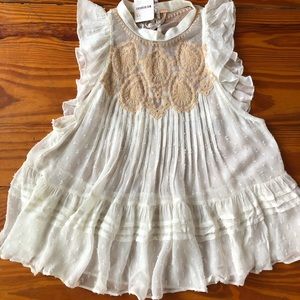 Cream top. Sleeveless/ ruffled. Two covered buttons and slightly open back.